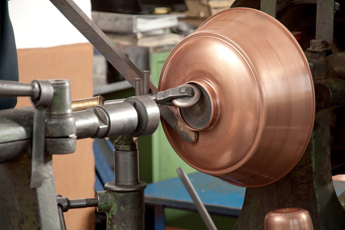 Copper shade being spun on a lathe